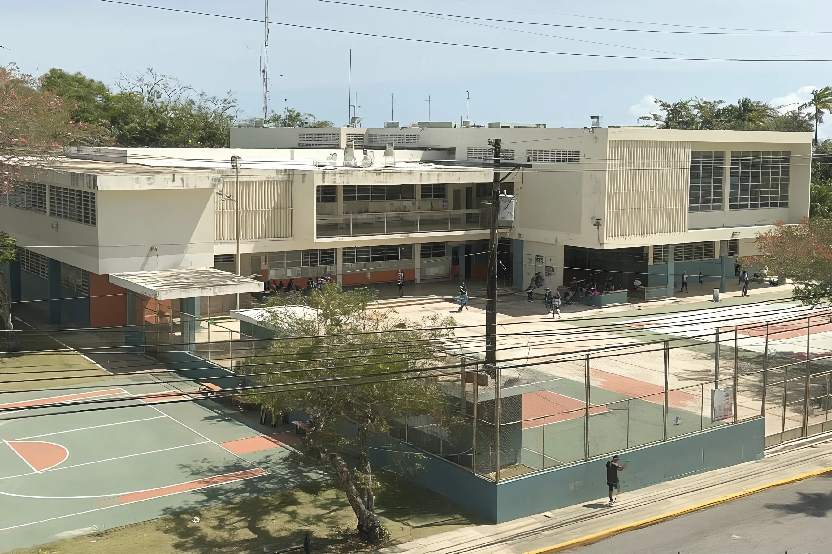Ilustración de una escuela pública de Puerto Rico: edificio de hormigón de dos plantas con persianas Miami, canchas de baloncesto y estudiantes en el patio